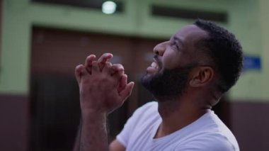 Minnettar Afrikalı Amerikalı adam Tanrı 'ya şükrediyor, gökyüzüne bakıp dua ediyor ve gülümsüyor. Mutlu, siyah Brezilyalı bir adam umutla ve inançla yukarı bakıyor.