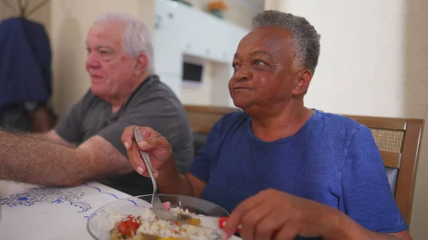 Yemek saatinde yemek yiyen yaşlı bir kadın, bir grup son sınıf öğrencisi. Brezilyalı yaşlı bir kadının yakın çekimi yemek yiyor.