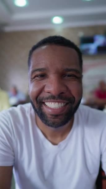 非洲裔美国年轻人对着摄像机微笑 一个快乐的黑人在30多岁时的近照脸在垂直录像中 — 图库视频影像