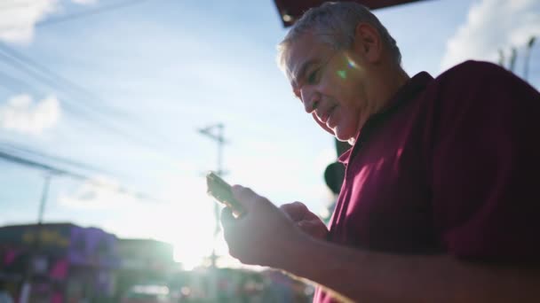 智能电话在阳光下城市环境 低视角景观中的快乐老人 — 图库视频影像