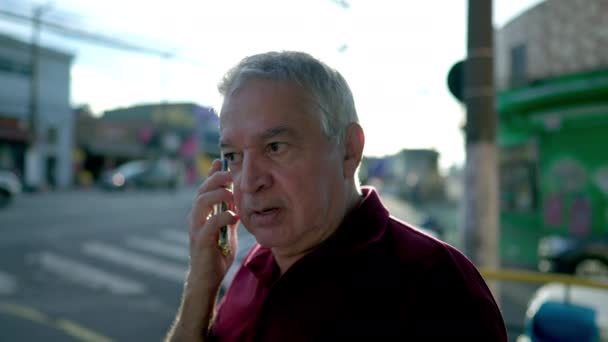 南アメリカの都市部で電話で話す幸せな高齢者の白人男性 現代技術通信を利用する高齢者 — ストック動画