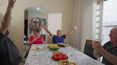 Neşeli son sınıf arkadaşları masaya oturmuş yemeğin gelişini kutluyorlar. Öğle yemeğinde yaşlı insanlar. Yaşlı kadın yemekle geliyor.