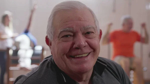 Portret Starszego Mężczyzny Uśmiechającego Się Aparatu Bliska Osobami Ćwiczącymi Tle — Zdjęcie stockowe