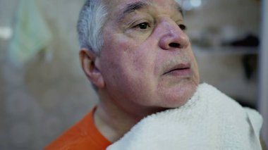 Yüzü sabah yıkandıktan sonra kuruyan yaşlı adamın yakın çekimi.