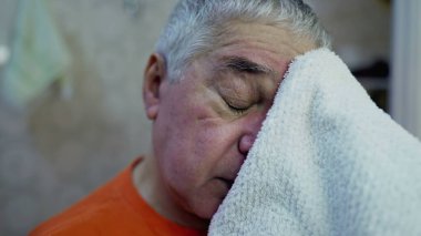 Yüzü sabah yıkandıktan sonra kuruyan yaşlı adamın yakın çekimi.