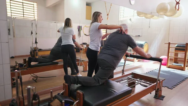 Pilates Instructor Guiding Senior Man Physiotherapy Session Exercise Machine — Stock Photo, Image