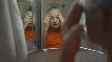 Sunbae, sabah ayini sırasında aynanın önünde kendini tımar ediyor. 70 'lerdeki yaşlıların ev hayatı. Yüz ve cilt incelemesi için hazırlanıyor.