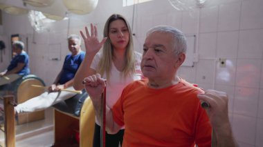 Pilates Makinesi 'nin kadın eğitmen tarafından çalıştırıldığı son sınıf egzersiziniz kutlu olsun. Yaşlılıkta vücut sağlığıyla ilgilenen yaşlı kişi rutin egzersiz yapar.