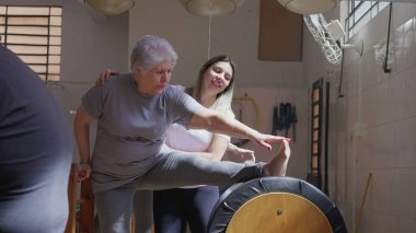 Pilates Eğitmeni Esneme Egzersizinde Yaşlı Kadına Rehber, Yaşlılıkta Aktif Yaşam Tarzı ve Esnekliği Destekliyor