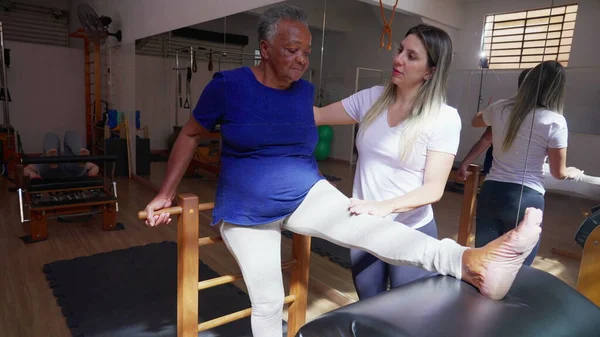 Pilates Coach Instructing Black Senior Woman Stretch Body Physiotherapy Rehabilitation — Stock Photo, Image