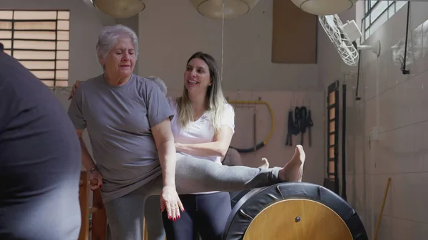 Pilates Instructor Guiding Elderly Woman Stretching Exercise Promoting Active Lifestyle — Stock Photo, Image