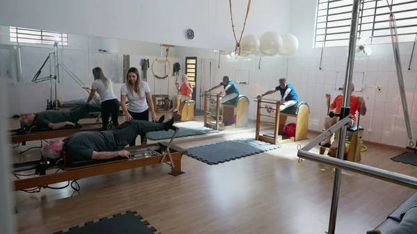 一群老年人在普拉多工作室锻炼 老年人的日常锻炼 指导老年人加强和伸展身体的女教练 — 图库照片