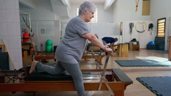 Older Woman Using Pilates Machine Stretch Body Elderly Person Workout — Stock Photo, Image