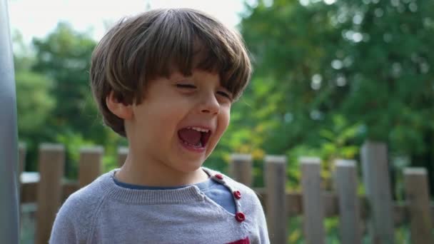 Ένα Χαρούμενο Μικρό Αγόρι Κοντά Πρόσωπο Χαμογελά Στέκεται Έξω Στο — Αρχείο Βίντεο