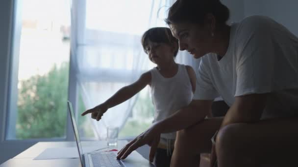 집에서 컴퓨터 앞에서아이와 일하는 어머니의 — 비디오