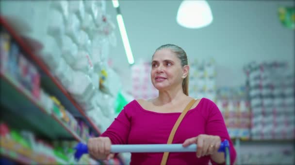 Женщина Средних Лет Передвигающаяся Проходу Супермаркете Просматривающая Продукты Полках Демонстрирующая — стоковое видео