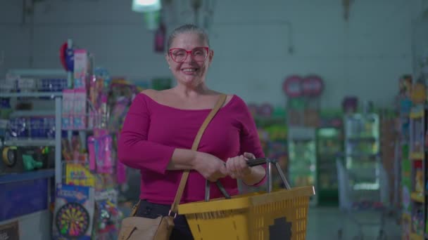Счастливая Женщина Покупатель Стоит Внутри Супермаркета Держа Корзину Руке Улыбаясь — стоковое видео