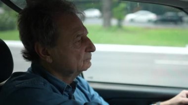 Şehirde araba süren beyaz bir adam.