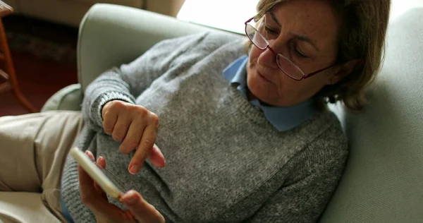 Wanita Tua Menggunakan Telepon Duduk Sofa Rumah Orang Senior Memegang — Stok Foto