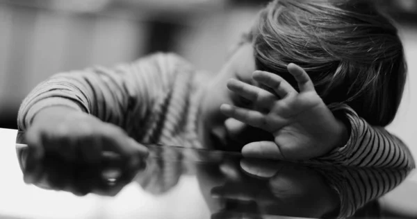 Triste Criança Deprimida Encostada Mesa Cobrindo Rosto Com Mão Monocromático — Fotografia de Stock