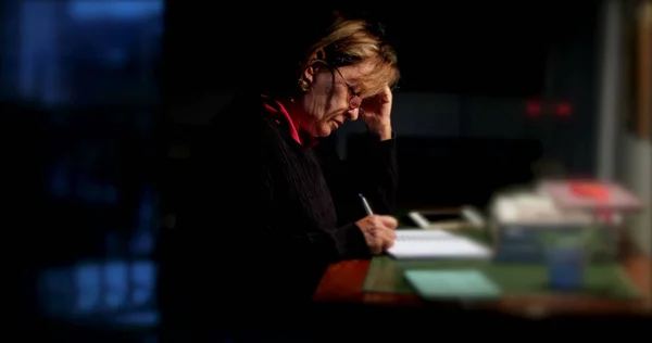 Nachdenkliche Seniorin Schreibt Nachts Notizen Auf Papier — Stockfoto