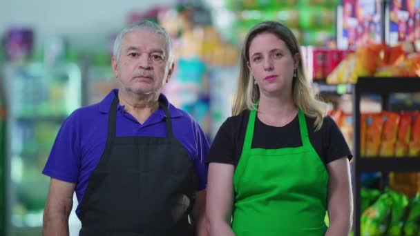 Tarafsız Ifadeli Iki Süpermarket Çalışanının Portresi Önlük Giyen Orta Yaşlı — Stok video