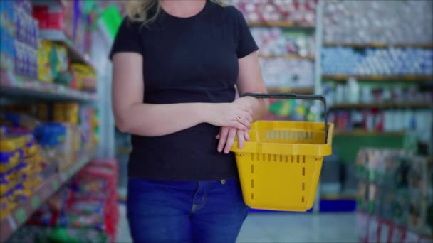 Kvinnlig Shoppare Som Håller Matvarukorg Handen Igenom Gången Snabbköpet Bläddra — Stockvideo
