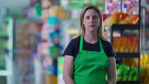 グリーンエプロンを身に着けているスーパーの深刻な女性従業員 厳しい心配表現と食料品店の中年スタッフ 就職活動 — ストック動画