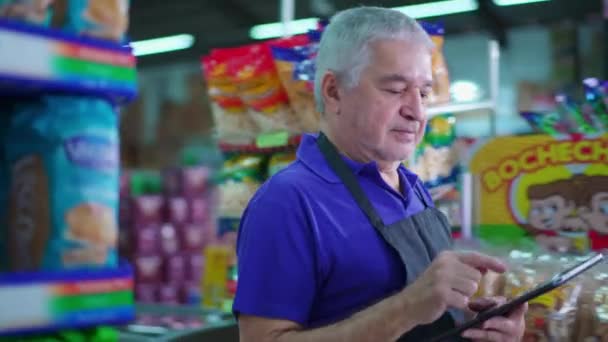 Старший Бразильский Менеджер Продуктового Магазина Проходящий Через Проход Супермаркета Осматривая — стоковое видео