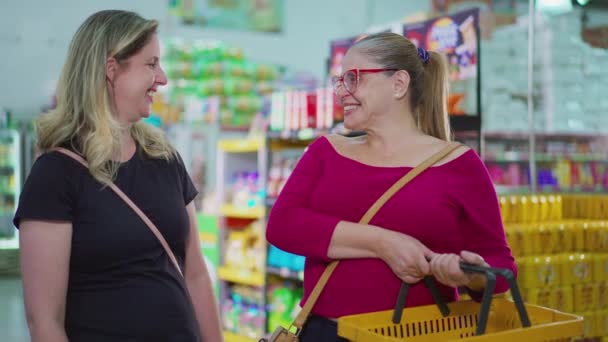 两个快乐的女购物者拿着篮子对着超级市场商店里的相机笑着 中年妇女在杂货店购物时面带微笑的画像 — 图库视频影像