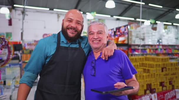 カメラのためにポーズをとる食料品店の2人の従業員 スーパーマーケットのブラジルの労働力 スタッフとシニアマネージャー — ストック動画
