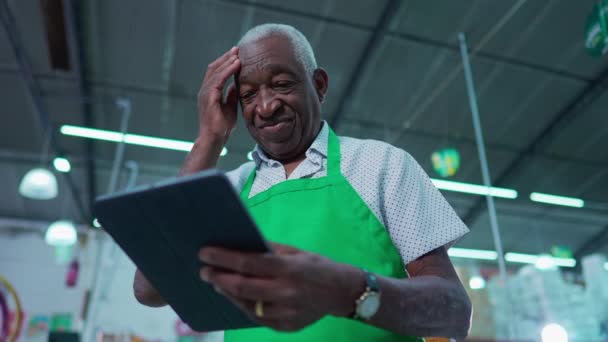 Ένα Απογοητευμένο Μαύρο Ανώτερο Προσωπικό Χρησιμοποιώντας Συσκευή Tablet Ξύσιμο Μέτωπο — Αρχείο Βίντεο