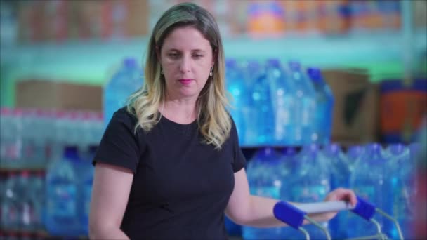 ショッピングカートブラウジングスーパーマーケットシェルフを持つ女性消費者 — ストック動画