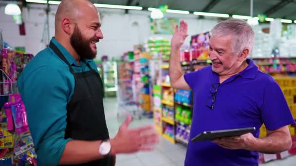 シニアマネージャーはスーパーで男性従業員に5人を与えています 上司は食料品店のビジネスで良い仕事のためのスタッフを祝福 — ストック動画