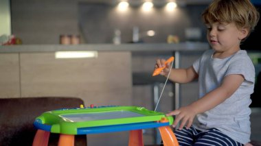 Çocuk çizim tahtası ile oynuyor. Heyecanlı ve hayal kırıklığına uğramış ADHD kavramı.