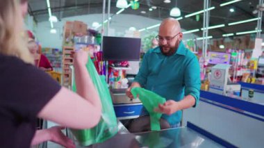Güney Amerika 'daki bakkal kasası. Brezilyalı çalışan süpermarket kasiyerinde çalışıyor.