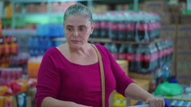 Süpermarket Koridorunda Tüketici Kadın Alışverişinin Yaşam Tarama Stili, Süpermarkette Orta yaşlı Kadın Tüketici Ürünleri