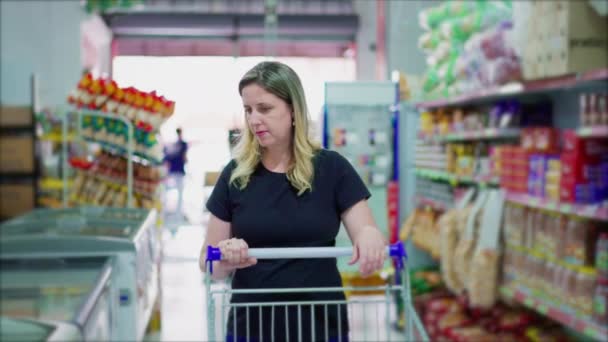 Női Fogyasztó Sétál Szupermarket Folyosón Böngészés Termékek Polcon Egy Fehér — Stock videók