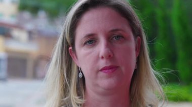 40 'lı yaşların ortasında kameraya ciddi bir ifadeyle bakan bir kadının yakın çekimi. Kafkas bir kadın orta yaşlı.