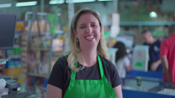 Süpermarketin Neşeli Bayan Çalışanı Kameraya Gülümsüyor Yeşil Önlüklü Arka Planda — Stok video