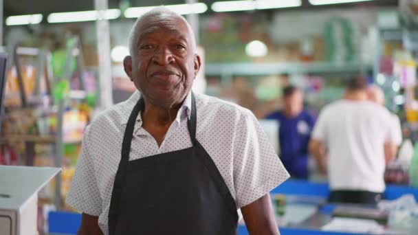 Portret Czarnego Starszego Personelu Supermarketu Stojącego Przy Kasie Patrzącego Kamerę — Wideo stockowe