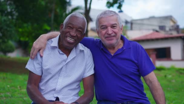 两个年长的朋友在城市里互相拥抱 非洲裔美国男性拥抱他的高加索朋友 描绘了街头友谊和友情的场景 — 图库视频影像