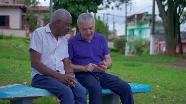 2人の高齢者多様な友人が都市環境で抱擁する アフリカ系アメリカ人の男性が 友情の場面を描いた彼の慎重な友人を抱きしめている — ストック動画