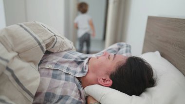 Kadın yataktan kalkıyor, yüzünü ovuyor ve güne başlıyor.