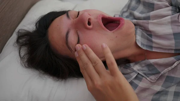 Esneyen Bir Kadın Sabah Uyanır Yatakta Uzanır Gözlerini Yüzünü Ovuşturur — Stok fotoğraf