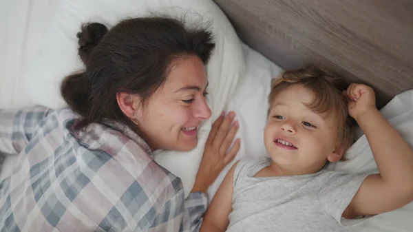 아침에 침대에 어머니와 사이의 가족적 애정을 나타내며 깨어나다 — 스톡 사진