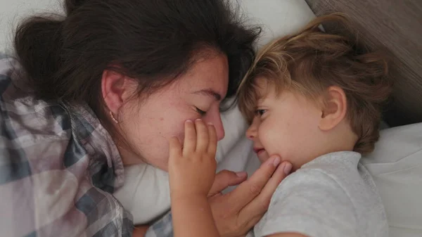 母子供愛と愛情で朝ベッド目覚めます小さな男の子愛お母さん家族瞬間 — ストック写真