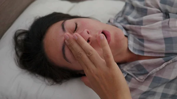 Esneyen Bir Kadın Sabah Uyanır Yatakta Uzanır Gözlerini Yüzünü Ovuşturur — Stok fotoğraf