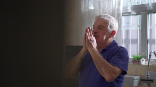 自宅のキッチンで神様に祈るシニア候補者 神のヘルプとSupportを求める希望的な高齢者の本物のスピリチュアルなシーン — ストック動画