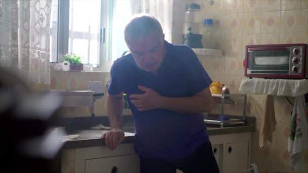 心臓攻撃 高齢者白人男性 緊急医療援助が必要 キッチンシンクによって単独で胸で手で地面に落ちる — ストック動画